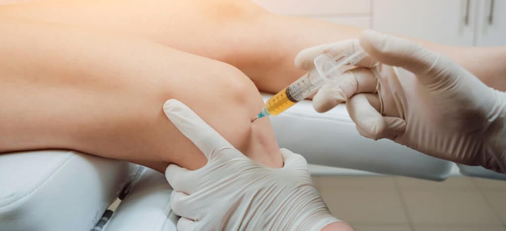 injecting vitamins in the patient's knees