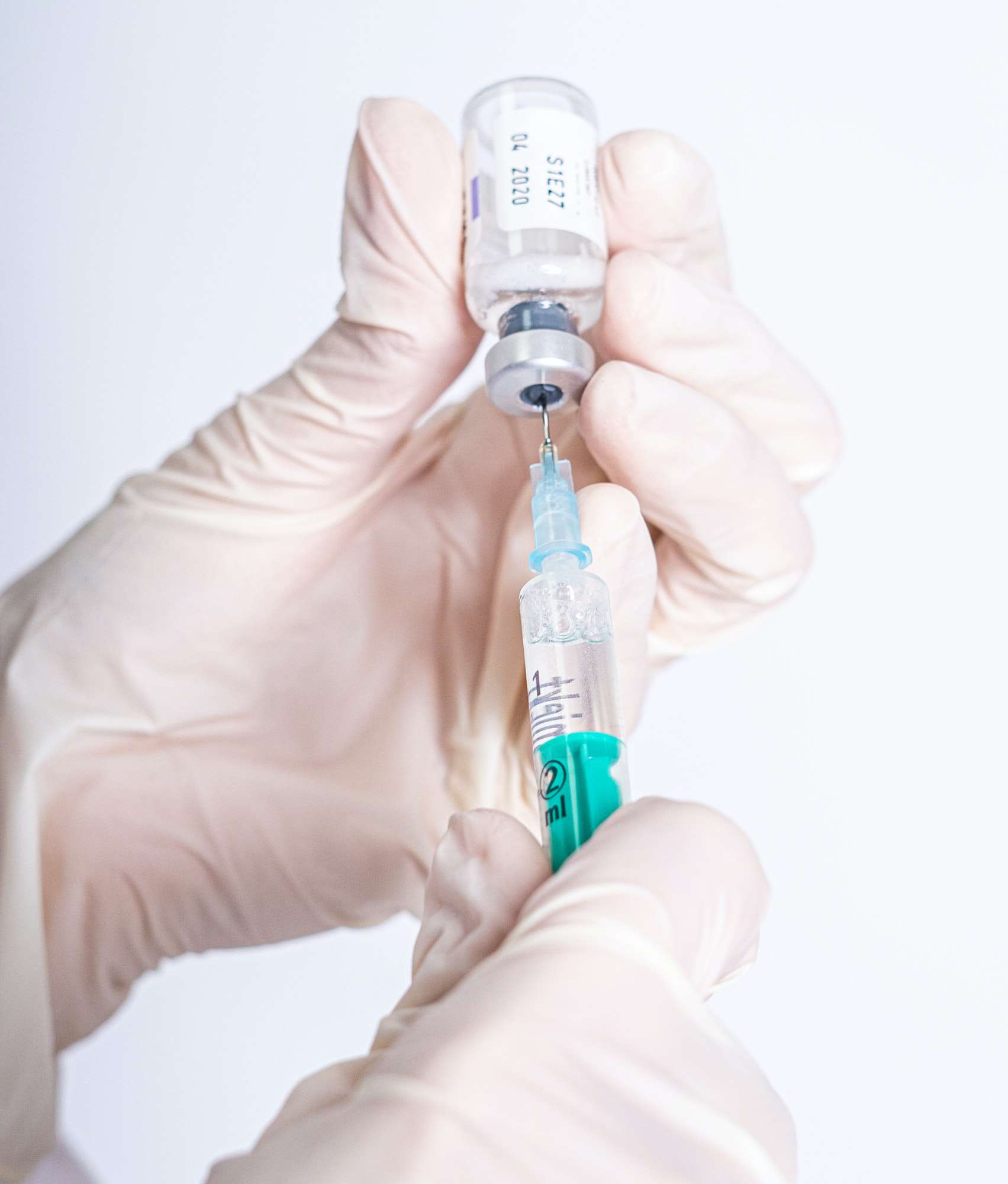 Selective focus shot of a hand holding an injection syringe with peptides
