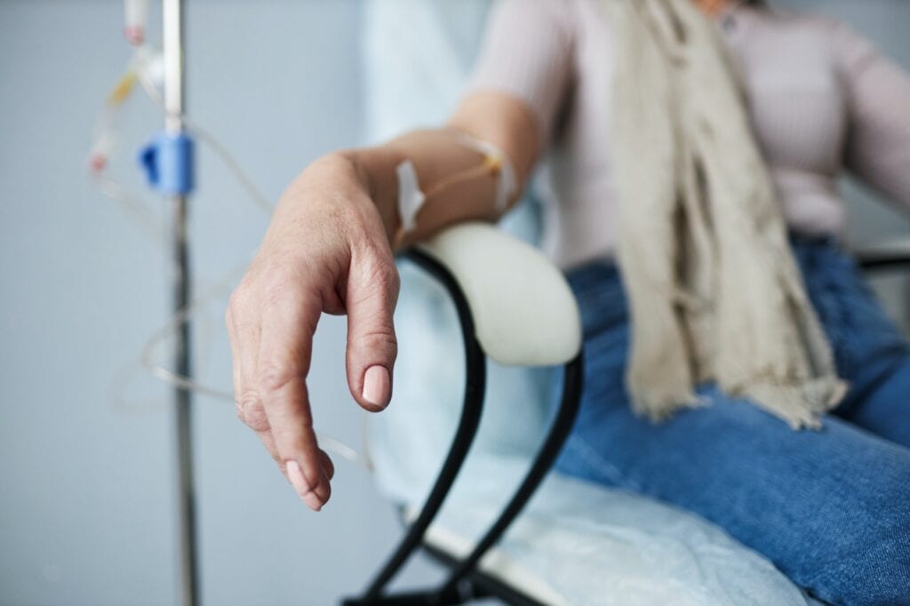 Closeup of woman in treatment session at hospital with IV drip