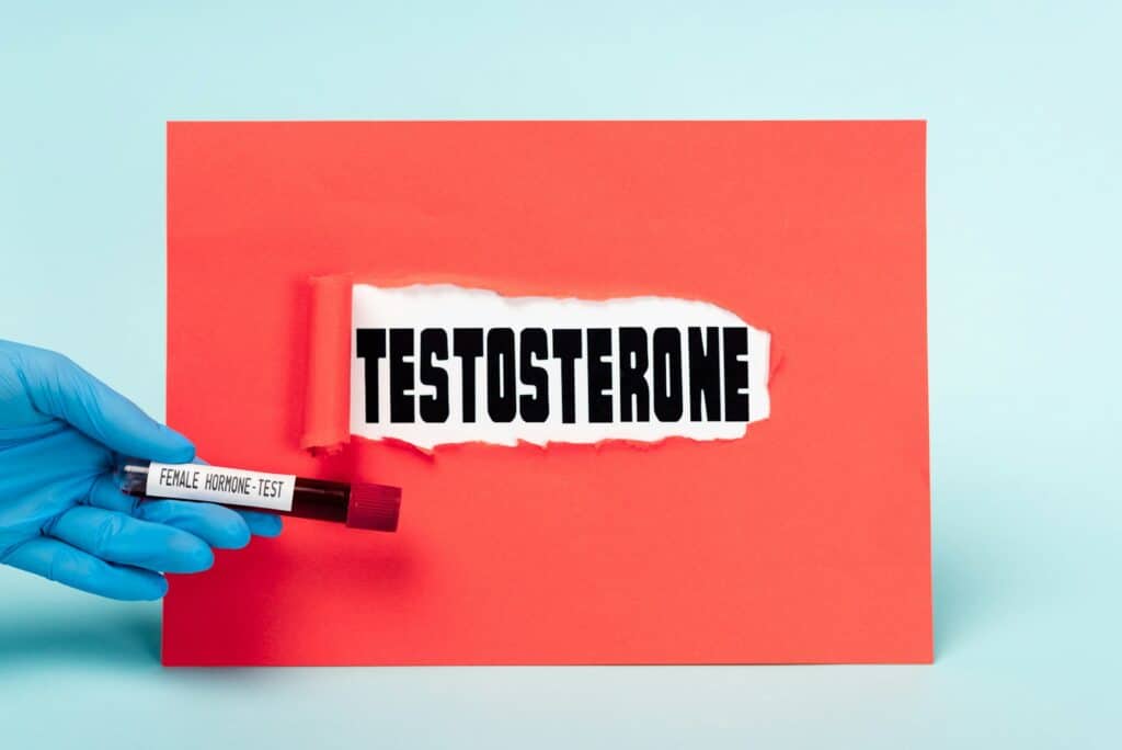 Cropped view of doctor holding test tube with blood sample of female hormone near testosterone