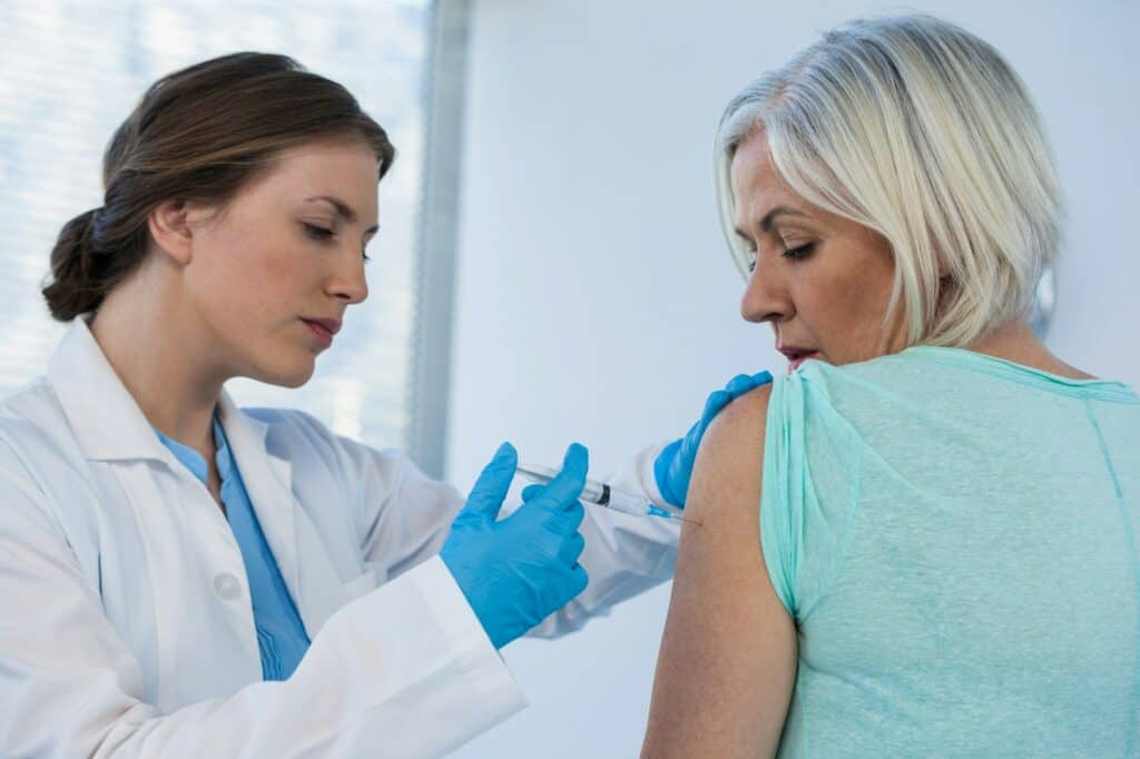 Doctor giving injection to patient